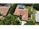 An aerial view of a single-story home featuring a screened in pool, mature landscaping, and a concrete driveway at 3030 Brighton Rd, Eustis, FL 32726