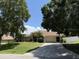 Home exterior featuring a long driveway, attached garage, and well-maintained landscaping at 3030 Brighton Rd, Eustis, FL 32726