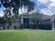 Charming single-story home with a lush front lawn, mature trees and well-maintained landscaping at 3030 Brighton Rd, Eustis, FL 32726
