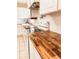 Kitchen with white cabinets, butcher block countertops, and stainless steel appliances at 312 North Blvd W, Davenport, FL 33837