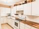 Bright kitchen with white cabinets, butcher block countertops, white appliances and farmhouse sink at 312 North Blvd W, Davenport, FL 33837