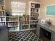 Office space featuring floor-to-ceiling bookshelves, a grey desk, and a comfortable seating area at 312 North Blvd W, Davenport, FL 33837