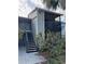 Two-story condo building with gray siding, black railings, and a stairwell leading to the upper units at 3748 Idlebrook Cir # 202, Casselberry, FL 32707