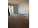 Spacious living room featuring neutral carpet, sliding glass doors to the balcony, and a white front door at 3748 Idlebrook Cir # 202, Casselberry, FL 32707