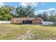 View of the expansive backyard featuring a screened porch and mature trees in a tranquil setting at 400 Sw 35Th St, Ocala, FL 34471