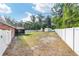 Expansive backyard enclosed by a white fence with large lawn and two storage sheds at 400 Sw 35Th St, Ocala, FL 34471