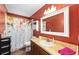 Bathroom featuring warm orange walls, a floral shower curtain, and a single sink vanity at 400 Sw 35Th St, Ocala, FL 34471