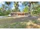 Charming home featuring a stone facade, complemented by lush landscaping and mature trees at 400 Sw 35Th St, Ocala, FL 34471