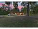 Charming home featuring a stone facade, complemented by lush landscaping and mature trees at sunset at 400 Sw 35Th St, Ocala, FL 34471