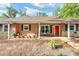 Welcoming front porch with seating, complemented by potted plants and a bright red door at 400 Sw 35Th St, Ocala, FL 34471