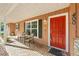Inviting front porch featuring seating, a red door, and brick flooring at 400 Sw 35Th St, Ocala, FL 34471