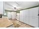 Spacious laundry room with tiled flooring, white cabinetry, a refrigerator, and access to the backyard at 400 Sw 35Th St, Ocala, FL 34471