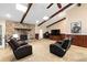 Cozy living room features a stone fireplace, wood beams, plush seating, and a large TV, perfect for relaxation and entertainment at 400 Sw 35Th St, Ocala, FL 34471