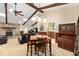 Cozy living room with a stone fireplace, wooden beams, and seamless integration with the dining area at 400 Sw 35Th St, Ocala, FL 34471