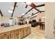 Open-concept kitchen and living area with wood beam ceilings, stone fireplace, and spacious layout, perfect for gatherings at 400 Sw 35Th St, Ocala, FL 34471
