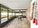 Screened-in porch with tiled flooring, an outdoor dining set, and a view of the backyard at 400 Sw 35Th St, Ocala, FL 34471
