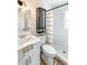 Bright bathroom with white cabinets, a shower, and an elegant dark-framed glass-doored cabinet at 412 Sunny Ct, Fruitland Park, FL 34731