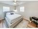 A modern bedroom with wood floors, light walls, a ceiling fan, and large sunny windows at 412 Sunny Ct, Fruitland Park, FL 34731