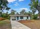 Charming single-story home boasts a freshly painted exterior, blue front door and well-manicured lawn at 412 Sunny Ct, Fruitland Park, FL 34731