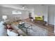 Bright living room features hardwood floors, stylish furniture and flows to the kitchen and dining area at 412 Sunny Ct, Fruitland Park, FL 34731