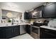 Modern kitchen with stainless steel appliances, granite counters, and an open design at 419 Aldama Ave, The Villages, FL 32159