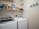 Clean laundry room equipped with washer, dryer, and shelving for storage at 419 Aldama Ave, The Villages, FL 32159