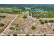 Wide aerial view of land dotted with houses, trees, and open fields near a lake at 4635 Brantley Rd, Groveland, FL 34736