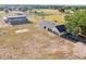 Wide aerial view of a property featuring a home, barn, and expansive green spaces, ideal for rural living at 4635 Brantley Rd, Groveland, FL 34736