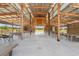 Spacious barn interior featuring a metal roof, wooden beams, tables and wagon wheel accents at 4635 Brantley Rd, Groveland, FL 34736