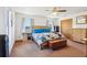 Spacious bedroom with a wooden bed frame, neutral tones, and ample natural light from large windows at 4635 Brantley Rd, Groveland, FL 34736