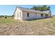 Rear view of house exterior with stucco siding, windows, and green grass at 4635 Brantley Rd, Groveland, FL 34736