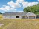 Exterior rear view of home with light-colored walls, a dark roof, and a lush lawn at 4635 Brantley Rd, Groveland, FL 34736