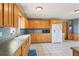 Well-lit kitchen boasts white appliances, wood cabinetry and tile floors at 4635 Brantley Rd, Groveland, FL 34736