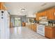 Sunlit kitchen with a gas stove, white appliances, and a breakfast bar with outdoor views at 4635 Brantley Rd, Groveland, FL 34736