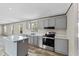 Contemporary gray kitchen with stainless steel appliances and bright lighting at 48 Oakridge Dr, Frostproof, FL 33843