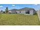 Green backyard features a privacy fence, sliding glass doors, and ample space for outdoor activities at 4905 Vellacito Way, Davenport, FL 33897
