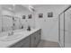 Modern bathroom with dual sinks, a large mirror, and a glass-enclosed shower at 4905 Vellacito Way, Davenport, FL 33897