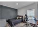 Bedroom with a gray accent wall, black bedding, and a gaming desk with a black and white gaming chair at 4905 Vellacito Way, Davenport, FL 33897