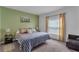 Comfortable bedroom with a green accent wall, plush bedding, and a window with light-filtering curtains at 4905 Vellacito Way, Davenport, FL 33897