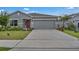 Well maintained single-story house with a two-car garage and nicely landscaped front yard at 4905 Vellacito Way, Davenport, FL 33897