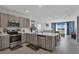 Modern kitchen with stainless steel appliances, stone countertops, and open layout to the living room at 4905 Vellacito Way, Davenport, FL 33897