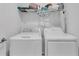 Well-lit laundry room featuring a white washer and dryer with shelving and storage space above at 4905 Vellacito Way, Davenport, FL 33897