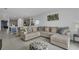 Spacious open-concept living room featuring a large sectional sofa and neutral decor flowing to kitchen at 4905 Vellacito Way, Davenport, FL 33897
