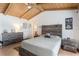 Cozy bedroom featuring rustic wood furniture, tile floors, and beamed ceiling with ceiling fan at 5045 Maui Cir # 12, Orlando, FL 32808