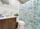 Clean bathroom with a vanity, toilet, and a tub with a decorative curtain at 515 Scenic St, Leesburg, FL 34748