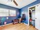 Bedroom featuring hardwood flooring, blue walls, a ceiling fan, and a large window at 515 Scenic St, Leesburg, FL 34748