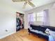 Bedroom featuring hardwood flooring, a ceiling fan, sofa and open closet at 515 Scenic St, Leesburg, FL 34748