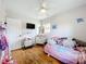 Cozy bedroom featuring wood floors, a ceiling fan, and bright, neutral walls at 515 Scenic St, Leesburg, FL 34748