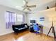 Bedroom features hardwood flooring, a ceiling fan, sofa, desk and chair and plenty of natural light at 515 Scenic St, Leesburg, FL 34748