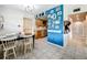 Dining area with a black table, white chairs, and a decorative blue accent wall at 515 Scenic St, Leesburg, FL 34748